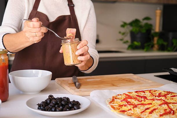 istock Person preparing homemade tuna pizza in kitchen 2247919771