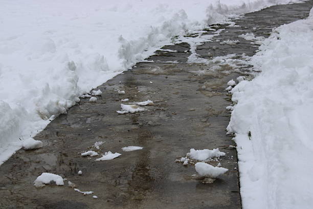 istock Snow-covered pathway being cleared in a residential area during winter morning 2247920934