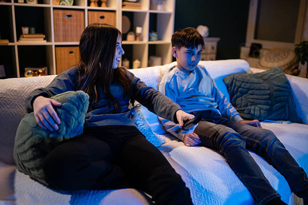 istock Siblings fighting over remote control watching tv at night 2247922964