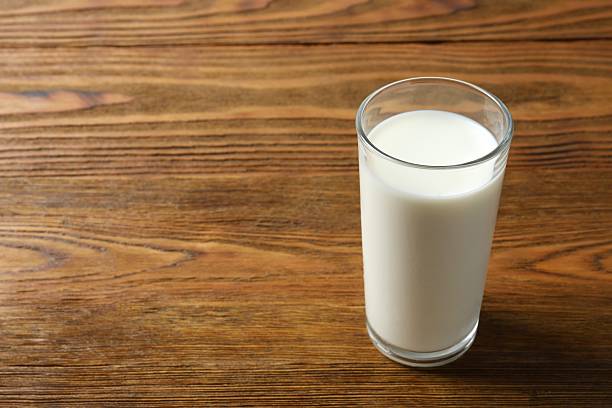 istock Milk in a glass top view on wooden background 2247926263