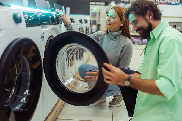 istock Two carefree customers are discussing the features and programs of a new washing machine, making a practical decision about white goods for their home 2247926293