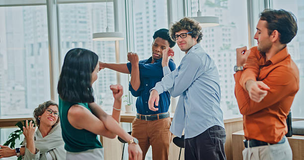 istock Group of diverse colleagues in casual clothing taking a break practicing stretching exercises to promote wellbeing and an active lifestyle in modern office. Sustainable business and finance concept. 2247928776