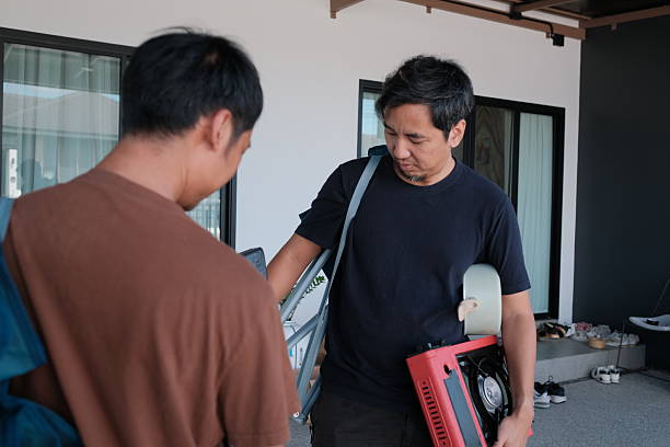 istock Two men are standing outside, one of them holding a red box 2247930404