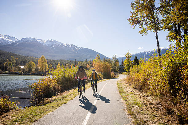 istock Women ride bicycles on pathway along lakeshore, Whistler 2247931140