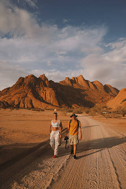 istock Confident Couple Walking on a Desert Road at Sunset in Namibia 2247940431