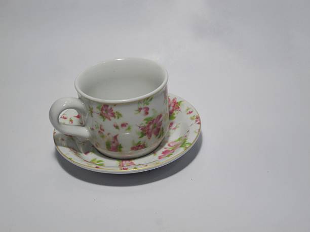 A finely crafted porcelain teacup featuring a delicate floral design that includes intricate patterns in blue and gold accents. The enchanting design adds an aura of elegance and sophistication.