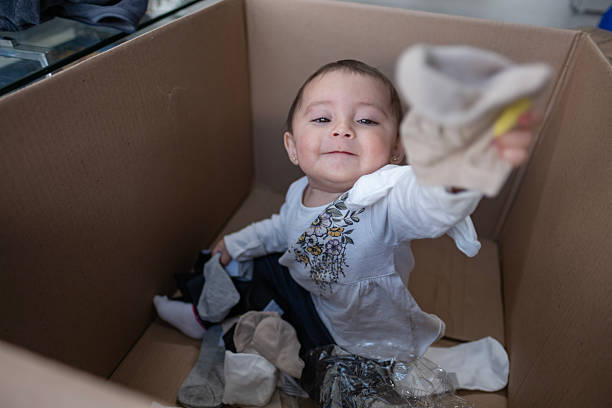 istock baby entertained playing inside a cardboard box 2247944459