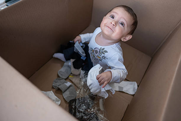 istock baby entertained playing inside a cardboard box 2247944463