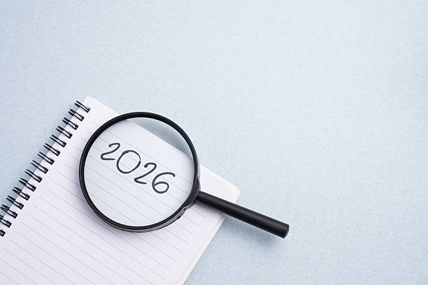 istock Happy New Year 2026 and a notepad on a colored background. Layout for writing annual business plans, schedules, as well as New Year's resolutions and goals. 2247944585