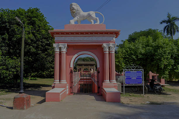 murshidabad, west bengal, india- november 19, 2025: historic pink entrance gate topped with white lion statue leading to the underground 'kathgola bauri – a 18th-century stepped water reservoir and cooling chamber of zamindars