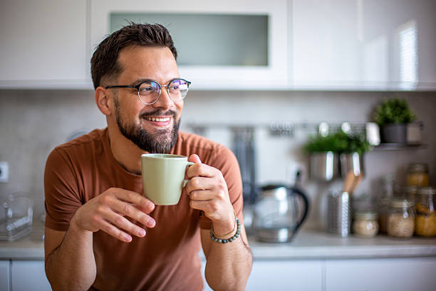 istock Smiling man enjoying morning coffee in modern kitchen 2247951976