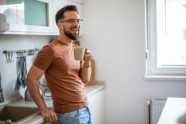 istock Happy man laughing enjoying coffee in kitchen 2247951995