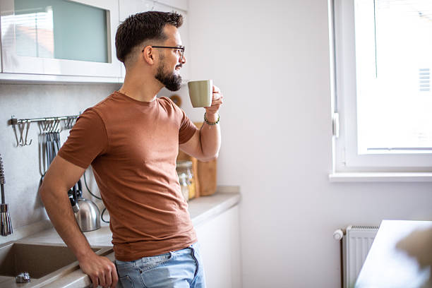 istock Man enjoying morning coffee cup in modern kitchen 2247952049