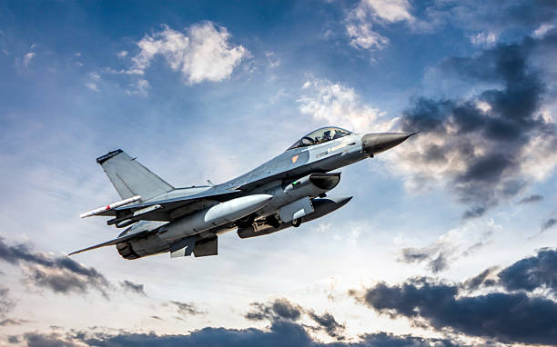 istock F-16 Fighter Jet flying in clouds at sunset 2247953330