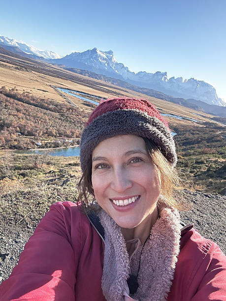 istock Woman smiling taking selfie with mountain landscape 2247953529