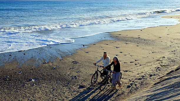 shadow of a cycling couple on the golden sand beach of Aveiro, Portugal