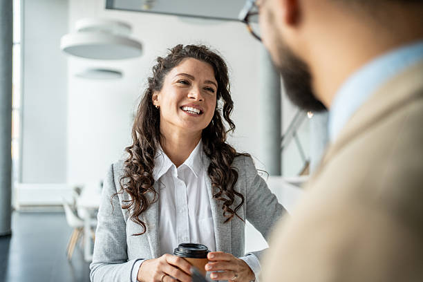 istock Businesswoman laughing while talking with colleague during coffee break 2247958560