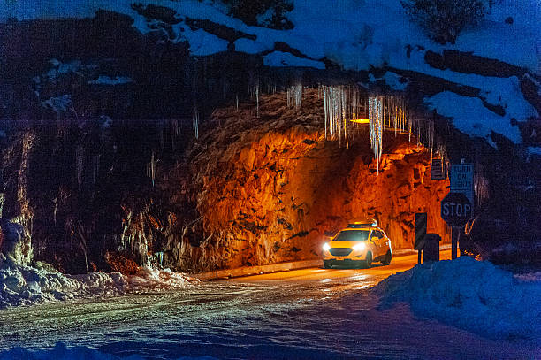 Mariposa County, United States - January 1, 2022. Early morning, pre-dawn scene showing a car passing through a tunnel in a frozen Yosemite National park, near the famous Tunnel view lookout.