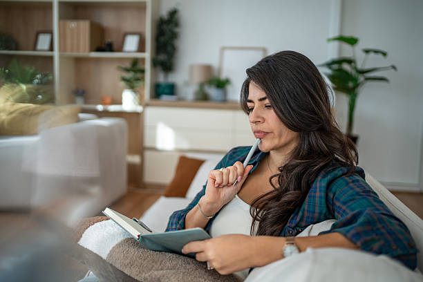 istock Woman thinking while writing in journal at home 2247963033