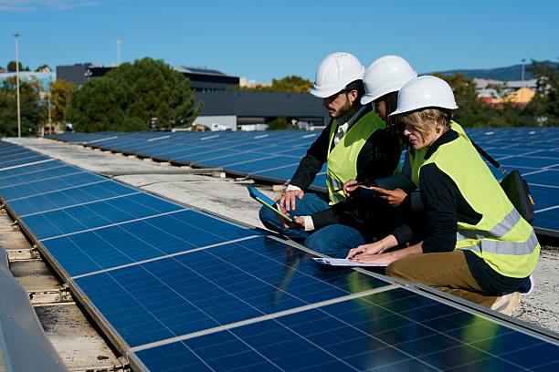 istock Engineers inspecting solar panels on rooftop discussing renewable energy 2247965872
