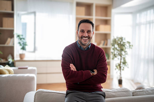 istock Confident man smiling at home in living room 2247968048