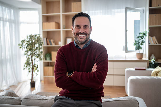 istock Confident man smiling sitting in bright home living room 2247968062