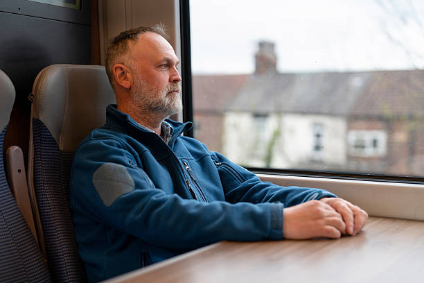 istock Man gazes out the train window on a quiet journey 2247968935