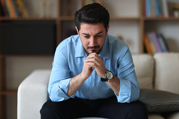 istock Thoughtful serious man sitting on sofa at home, lost in thoughts 2247969657