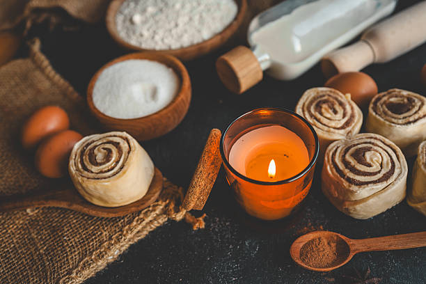 istock Cinnamon rolls with ingredients and candle on a dark background 2247977978