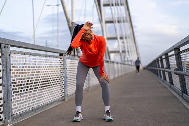 istock Young woman resting during intense urban running workout 2247978486