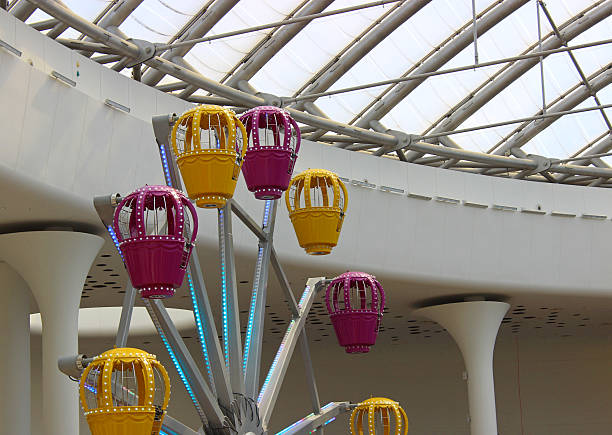 Multicolored ferris wheel in the lobby of a shopping center covered with transparent panels