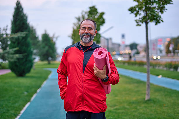 istock Mature man holding yoga mat preparing for exercise in park 2247983814