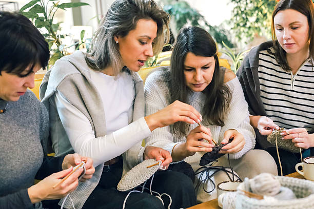 istock Women learning crochet together in cozy creative workshop, focusing on handmade round pieces 2247986172