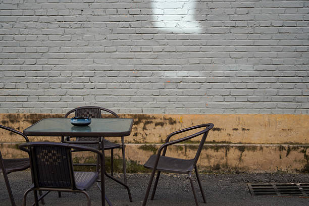 istock An empty outdoor table set against a weathered brick wall 2248000194