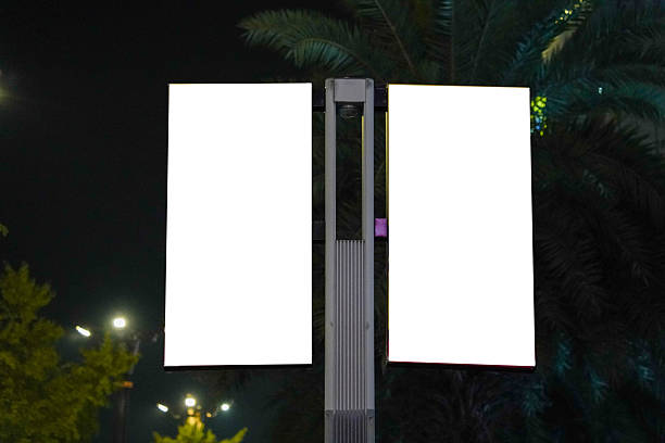 Large blank billboard on a street wall, banners with space to add your own text, night view