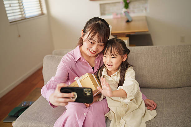 istock Mother and Daughter Taking a Selfie with a Gift at Home 2248013841