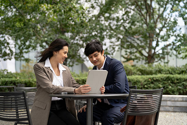 istock Two Asian people using an Ipad in the city 2248016548