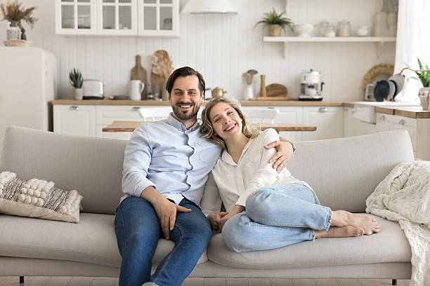 istock Portrait happy spouses resting on sofa hugging looking at camera 2248019668