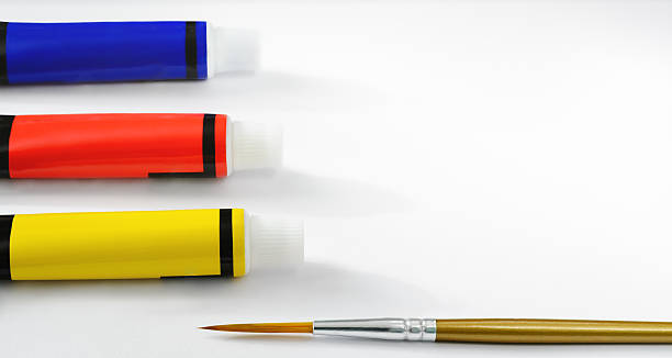 istock White background with yellow, red and blue paint tubes and a brush 2248026006