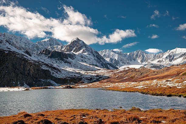 Altai mountains highlands. Snow capped ridge and lake at autumn time at sunny day