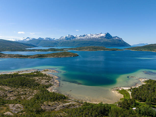 istock Aerial View over a beatiful beach coastline with snowy mountain range in the background during a sunny summer day in 2025 in the nature reserve Trollpollen, Norway 2248028547