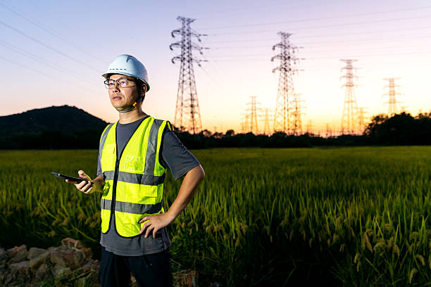 istock An Asian engineer uses his mobile phone under a power line tower. 2248031707
