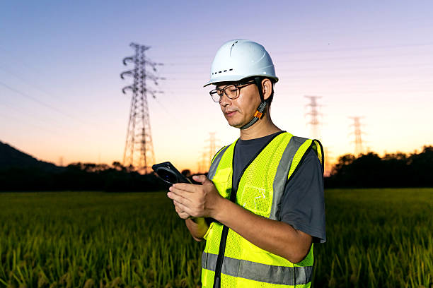 istock An Asian engineer uses his mobile phone under a power line tower. 2248031734