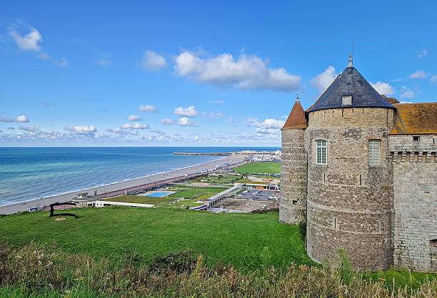 Dieppe, France - August 27, 2023 Chateau de Dieppe, a historic fortress perched on a cliff overlooking the turquoise waters of the English Channel. The stone castle with pointed towers has view to the town and a long pebble beach