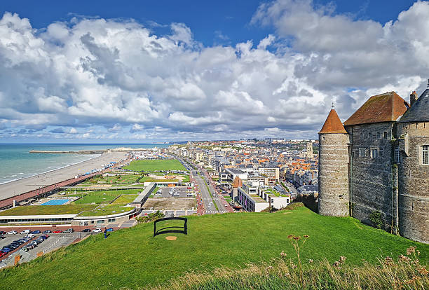 Dieppe, France - August 27, 2023 An elevated view captures Dieppe and its coastline. The historic stone castle with pointed towers overlooks the town and urban streets leading to a long pebble beach and the English Channel