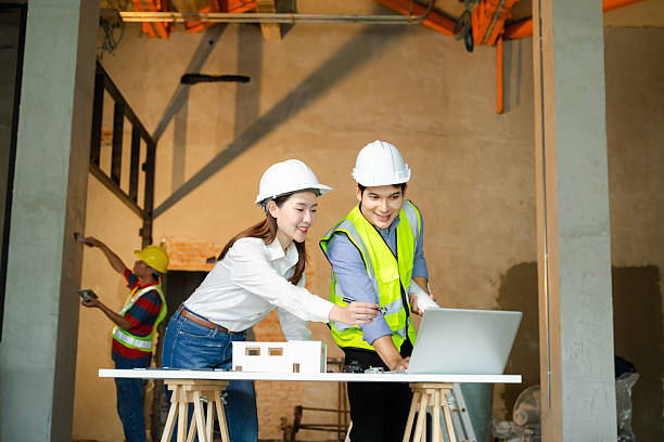 istock Two colleagues discussing data working and tablet, laptop with architectural project at construction site 2248033541