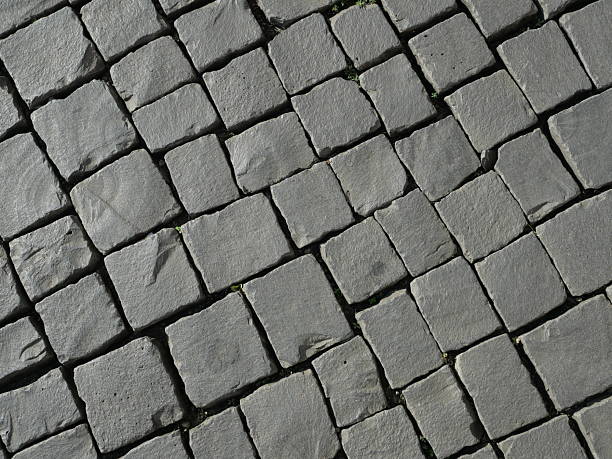 istock Mosaic pavement of gray natural stone blocks in diagonal pattern with shadow texture 2248039146