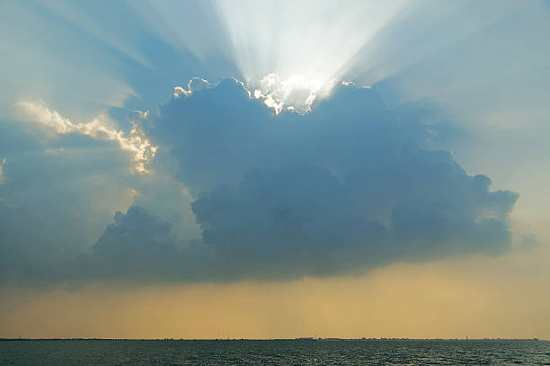 This captivating photo captures a breathtaking sunset over Çanakkale, Turkey. The sun's rays pierce through dramatic clouds, illuminating the Aegean Sea below. Ideal for travel and nature enthusiasts.