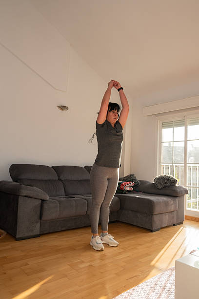 istock Woman stretching arms overhead during exercise at home 2248042372
