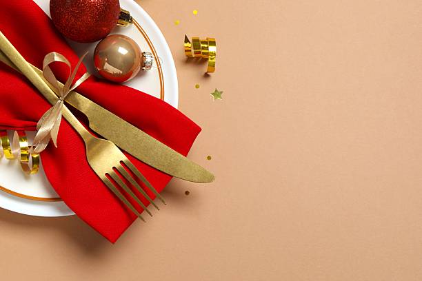 istock Elegant holiday table setting with white plates, gold flatware, red napkin, Christmas and New Year's celebrations 2248042885